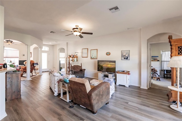 living room featuring hardwood / wood-style floors, a wealth of natural light, and decorative columns