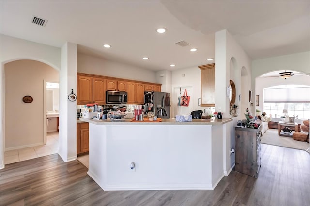 kitchen with kitchen peninsula, appliances with stainless steel finishes, wood-type flooring, and ceiling fan