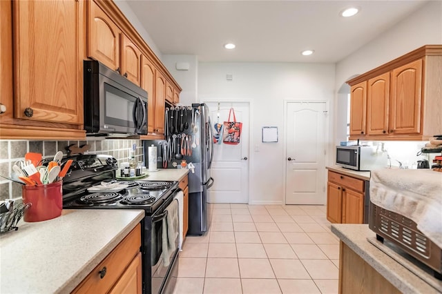 kitchen with decorative backsplash, light tile patterned flooring, and stainless steel appliances