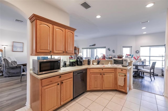 kitchen with light hardwood / wood-style floors, sink, kitchen peninsula, and black dishwasher