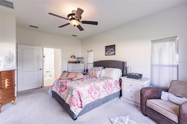 bedroom with light carpet, ceiling fan, and connected bathroom