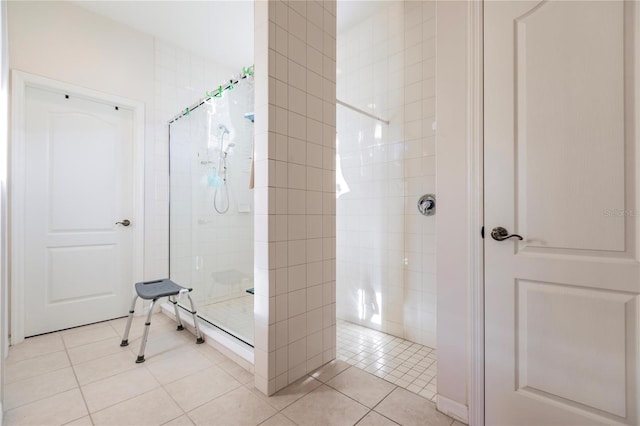 bathroom with tile patterned flooring and tiled shower