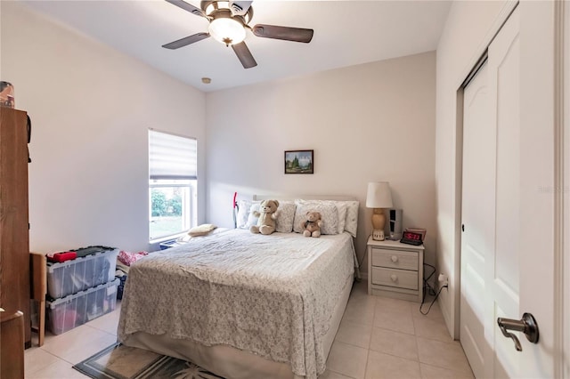 tiled bedroom with ceiling fan and a closet