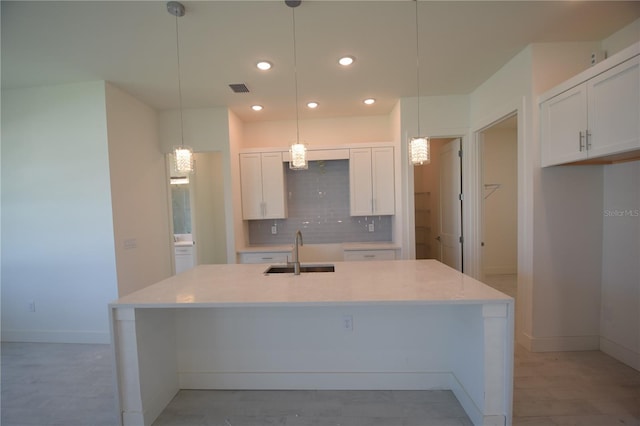 kitchen featuring white cabinetry, decorative backsplash, sink, and hanging light fixtures