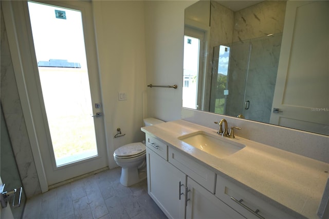 bathroom with a shower with door, toilet, and vanity