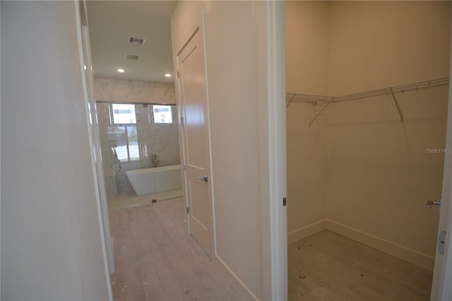 interior space featuring a washtub and hardwood / wood-style floors