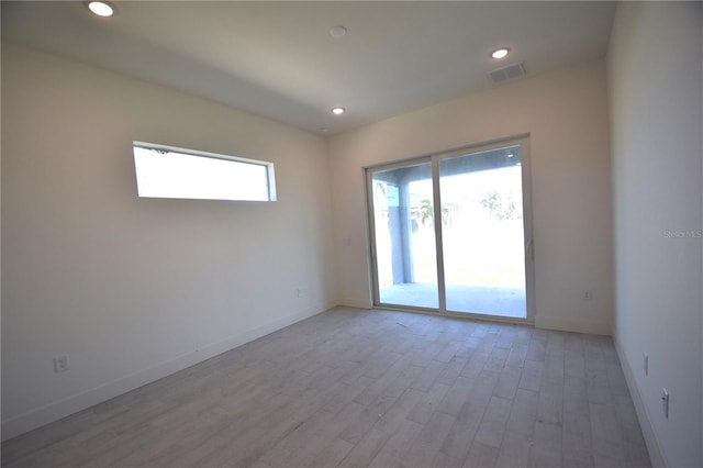 spare room featuring a wealth of natural light and light hardwood / wood-style floors