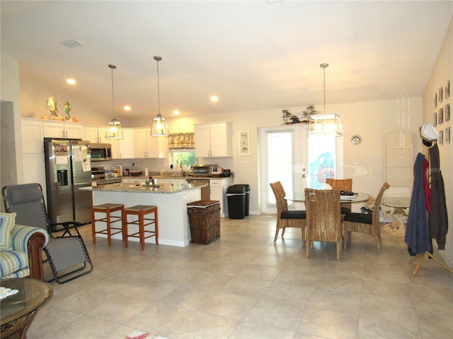 tiled dining area featuring french doors and vaulted ceiling