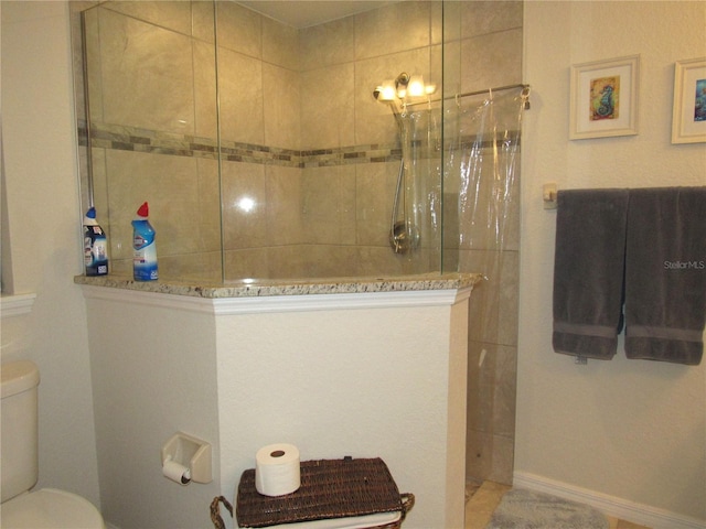 bathroom featuring toilet and a tile shower