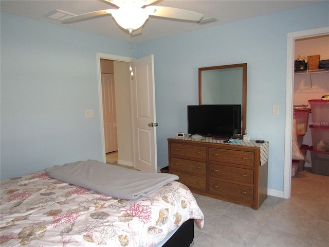 bedroom with light tile patterned floors, a spacious closet, ceiling fan, and a closet