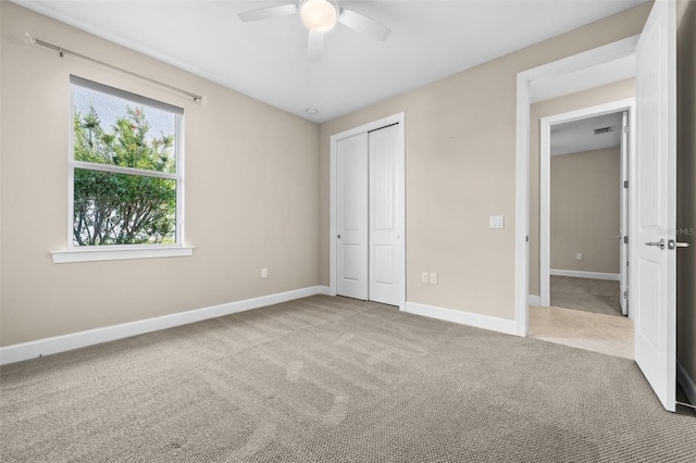 unfurnished bedroom featuring a closet, carpet flooring, and ceiling fan