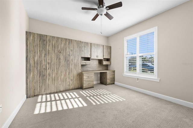 unfurnished office with ceiling fan and light carpet