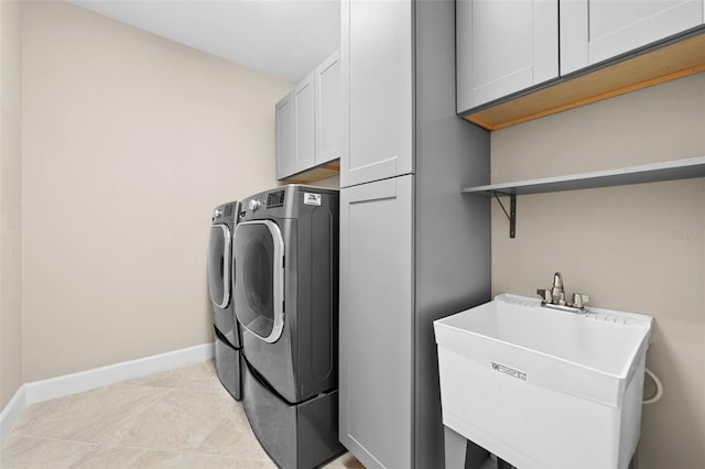 laundry area featuring cabinets, sink, washer and dryer, and light tile patterned floors