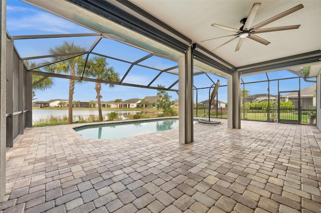 view of swimming pool featuring glass enclosure, a water view, ceiling fan, and a patio