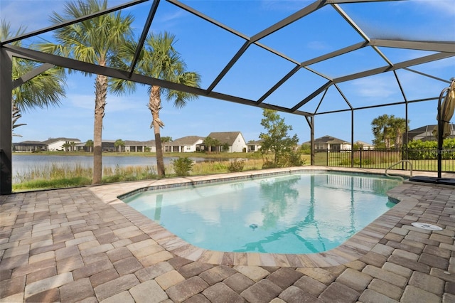 view of swimming pool featuring a patio, glass enclosure, and a water view