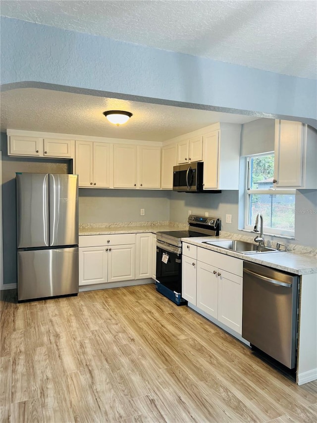 kitchen featuring light hardwood / wood-style floors, sink, white cabinetry, and stainless steel appliances