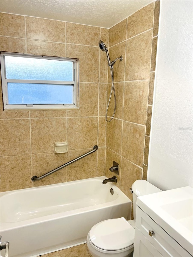 full bathroom featuring vanity, tiled shower / bath, a textured ceiling, and toilet