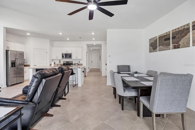 dining area featuring ceiling fan, light tile patterned flooring, and sink