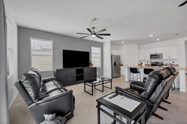 tiled living room with ceiling fan and a wealth of natural light