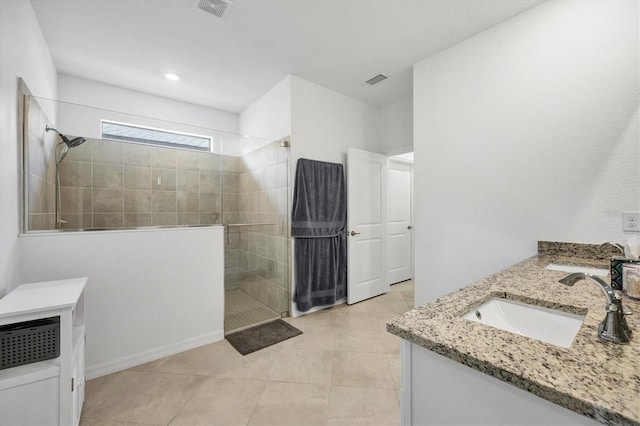 bathroom with vanity, tile patterned flooring, and tiled shower