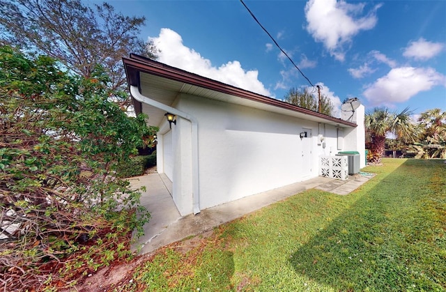 view of property exterior with a lawn, a garage, and central AC