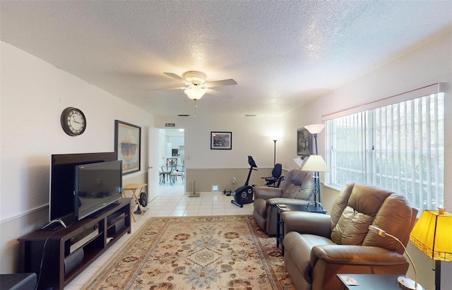 living room with light tile patterned floors, a textured ceiling, and ceiling fan