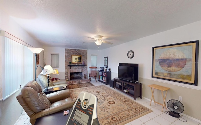 living room featuring ceiling fan, light tile patterned flooring, a textured ceiling, and a brick fireplace