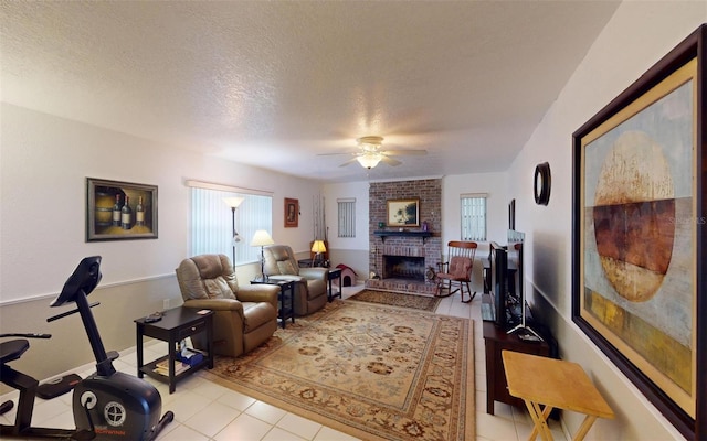 living room with plenty of natural light, ceiling fan, a textured ceiling, and a fireplace