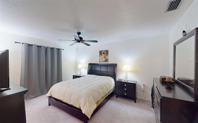 carpeted bedroom featuring ceiling fan and a textured ceiling