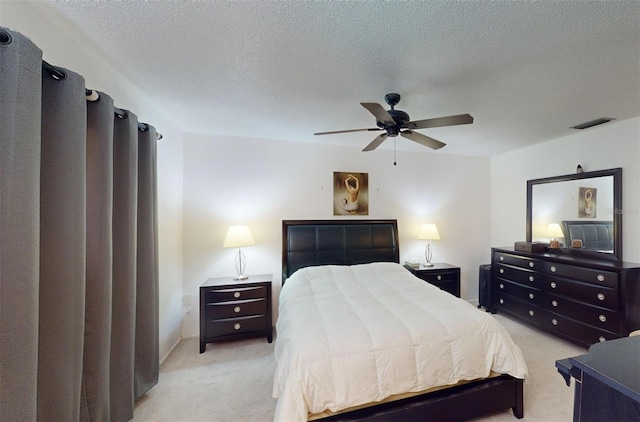 bedroom with light carpet, a textured ceiling, and ceiling fan