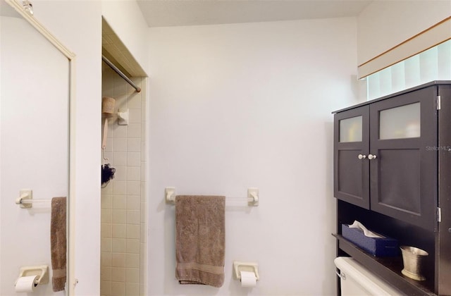 bathroom with tiled shower and toilet