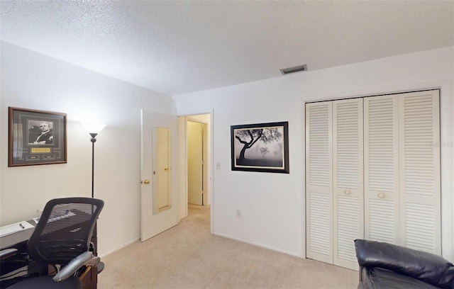 carpeted office space featuring a textured ceiling