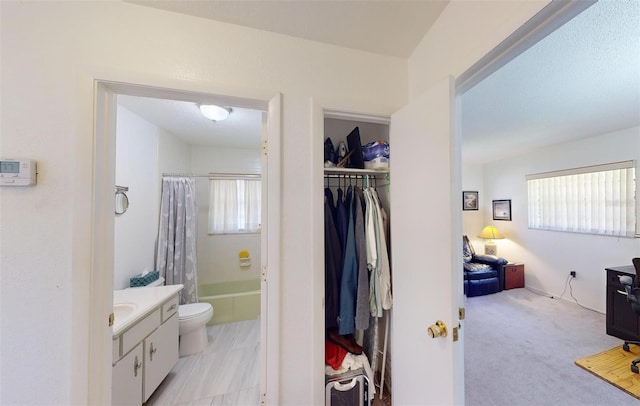 full bathroom with shower / bath combo with shower curtain, vanity, and toilet