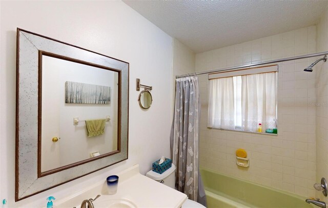 full bathroom featuring vanity, shower / tub combo, a textured ceiling, and toilet