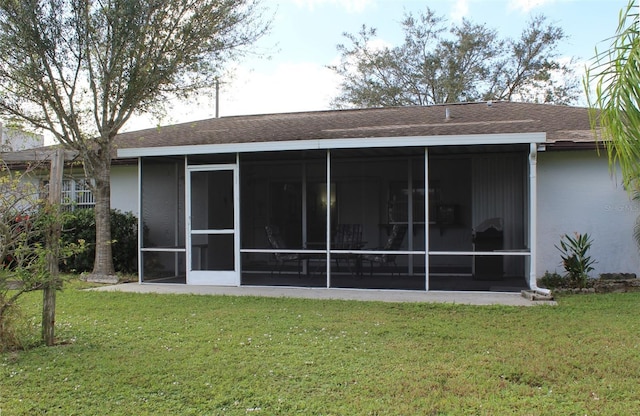 rear view of property with a yard and a sunroom