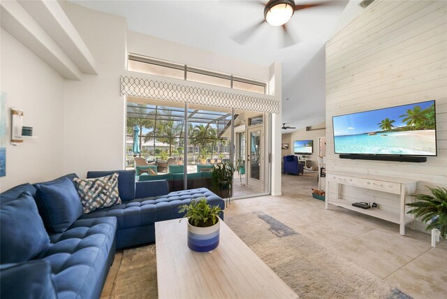 living room with ceiling fan, tile patterned floors, and high vaulted ceiling