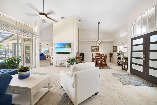 living room featuring ceiling fan, high vaulted ceiling, light tile patterned floors, and french doors