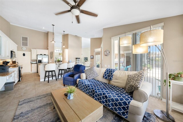 living room with light tile patterned flooring, ceiling fan, and plenty of natural light