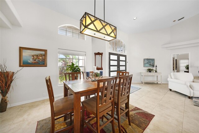 tiled dining area featuring a high ceiling