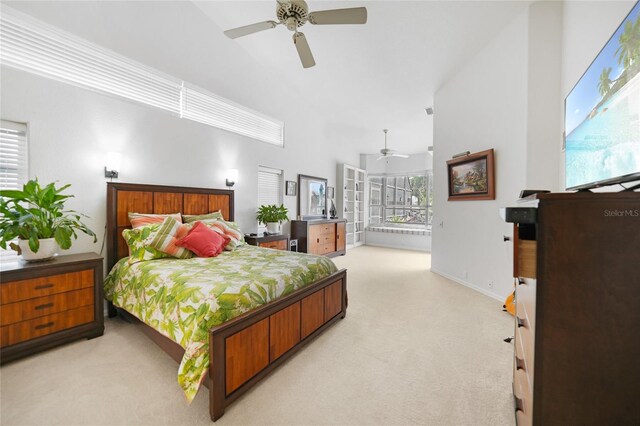 carpeted bedroom with ceiling fan and a high ceiling