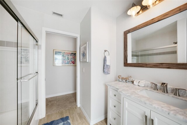 bathroom with walk in shower and vanity