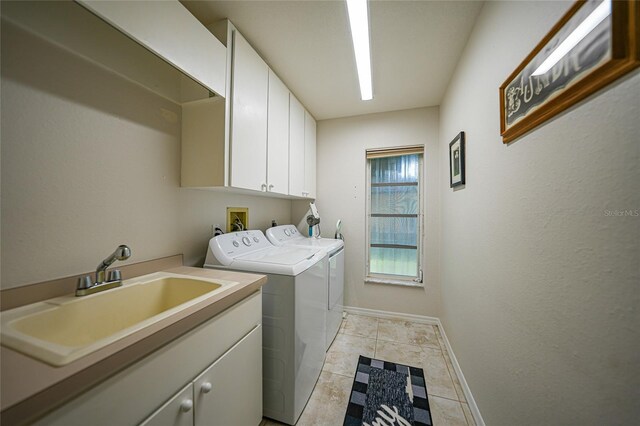 laundry area featuring light tile patterned flooring, cabinets, sink, and washing machine and clothes dryer