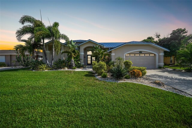 ranch-style home featuring a garage and a yard