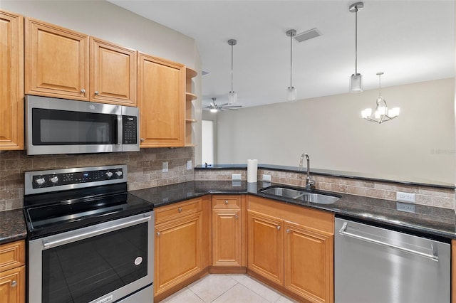 kitchen featuring stainless steel appliances, sink, light tile patterned floors, decorative light fixtures, and backsplash