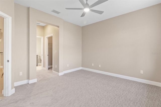 unfurnished bedroom featuring a spacious closet, light carpet, and ceiling fan