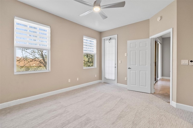 carpeted spare room featuring ceiling fan