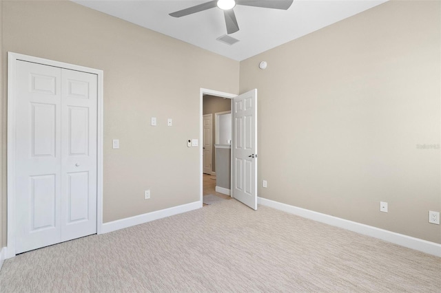 unfurnished bedroom with ceiling fan, a closet, and light colored carpet