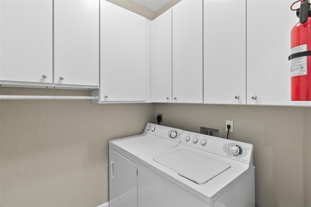 laundry area featuring cabinets and washing machine and clothes dryer