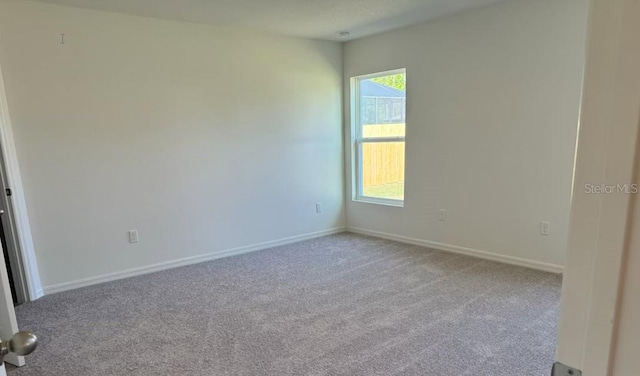 unfurnished room featuring light carpet