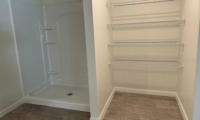 bathroom featuring walk in shower and hardwood / wood-style flooring